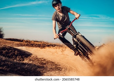 Close up, low angle view of mountain biker on a dusty road