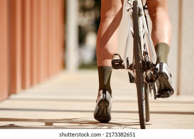 Close Up, Low Angle View On A Bike, Back Wheel On Foreground. Man's Legs Riding His Bicycle On Road In Summer. Concept Of Extreme Cycling