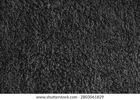 Close up, macro black microfiber bath towel texture, soft fluffy terry cloth surface, absorbent fabric details. Cozy textile material background for bathroom, cleaning or spa concepts