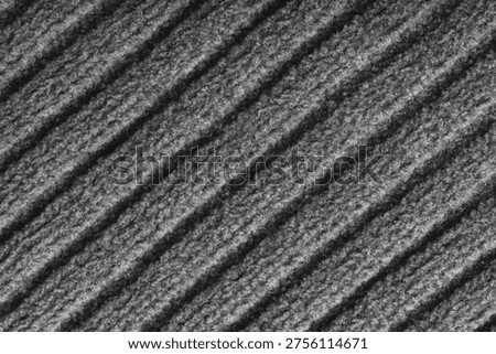 Close up, macro of gray colored knitted fabric with diagonal relief ribbed pattern and soft wool texture. Detailed textile surface, knitwear background, fashion, backdrop, design element.