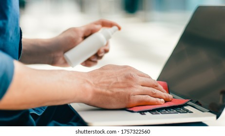 Close Up. Man Spraying Spray On The Surface Of A Laptop