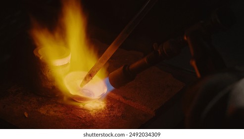 Close up: melting gold to create the right sample to make gold jewelry. The work of a master in a handmade jewelry workshop. - Powered by Shutterstock