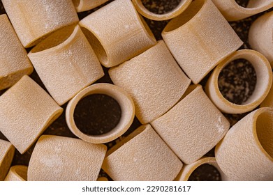 Close up. Pasta and egg, freshly prepared. Homemade pasta from durum wheat. Handmade pasta on a brown background is the subject of this photo. The noodles are various shapes and sizes.  - Powered by Shutterstock
