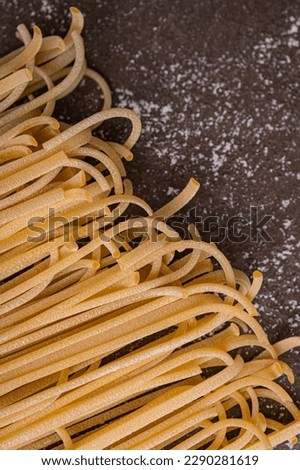 Close up. Pasta and egg, freshly prepared. Homemade pasta from durum wheat. Handmade pasta on a brown background is the subject of this photo. The noodles are various shapes and sizes. 