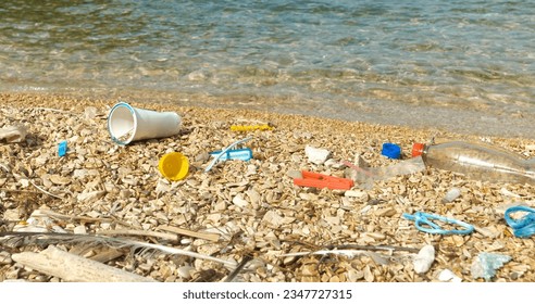 CLOSE UP: Pebble beach polluted by plastic waste washed up by the Adriatic Sea. Sad sight for an all too common occurrence on beautiful seashores. Coastal landscape where garbage remains accumulate.