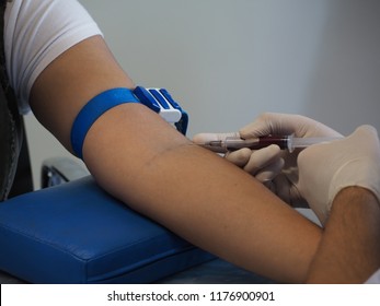 Close Up, Puncture Of A Vein Through The Skin In Order To Withdraw Blood For Analysis.The Nurse Uses A Syringe To Venipuncture The Patient's Arm.