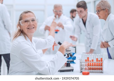 Close Up. Senior Female Scientist Sitting At A Laboratory Table.