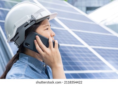 Close Up, Side View Portrait With Copy Space Of A Professional Asian Woman Wearing Safety Helmet, Holding Mobile Phone, Making A Call. Engineer, Worker, Or Architect Working With Solar Roof Concept.