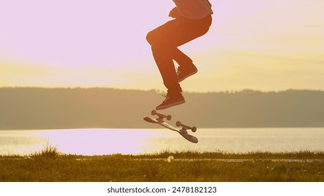 CLOSE UP: Silhouetted skateboarder skateboarding and jumping 360 flip trick on promenade along the ocean at golden light sunset. Skateboarder riding skateboard at sunrise at seaside - Powered by Shutterstock