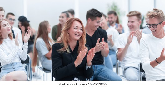 close up. smiling young woman applauding sitting in conference room