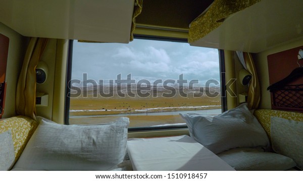 CLOSE UP: Stunning vista from the Trans-Himalayan\
Railway from a private cabin. Breathtaking view of the Himalayan\
mountains from a first class cabin as sleeper train travels along a\
river in Tibet.