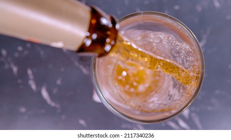 CLOSE UP, TOP DOWN, DOF: Close Up Shot Of Pouring Refreshing Beer Into A Glass Mug. Frothing Pale Ale Gets Poured From A Retro Bottle. Ice Cold Beer Gets Poured Out Of A Brown Bottle And Into A Glass