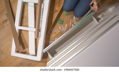 CLOSE UP, TOP DOWN: Female Moving Into Her New Apartment Unboxes A Modern White Chest Of Drawers. Unrecognizable Young Woman With Red Nails Finishes Unpacking A Trendy Dresser Drawer In Her Bedroom.