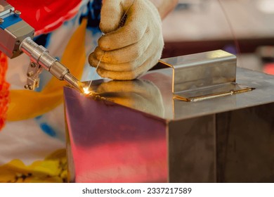 Close up: welder hands using portable handheld laser welding machine. Manufacturing, industrial, equipment, technology and metalworking concept - Powered by Shutterstock