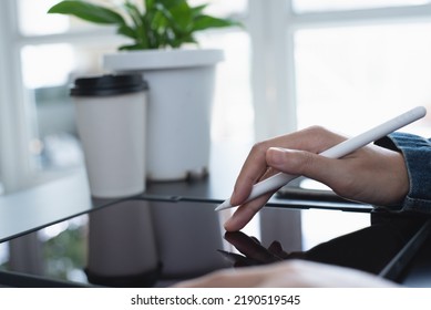 Close up, woman hand with stylus pen using digital tablet, finger touching on screen, online working at home office. Student studying online class, reading ebook via E-reader mobile app, online study