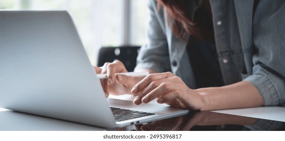 Close up, woman hand typing on laptop computer keyboard. Business woman online working on laptop computer, surfing the internet, searching the information at home office, e-learning - Powered by Shutterstock