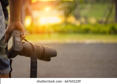 Close up, Yong man asian photographer holding digital camera DSLR with lens telephoto equipment for take a photo and picture memories travel landscape trip lifestyle. - Powered by Shutterstock