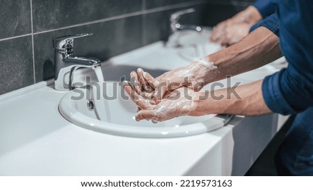 close up. young people wash their hands in a public restroom