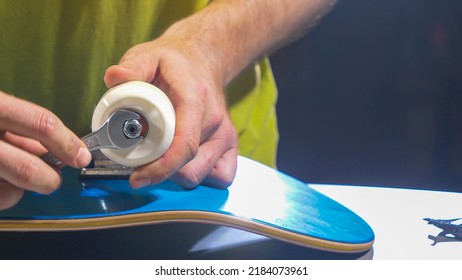 CLOSE UP: Young person mounting wheels on trucks of a new skateboard setup. Unrecognizable man putting wheels and placing nuts on skateboard trucks. Finishing part of assembling skateboarding setup. - Powered by Shutterstock