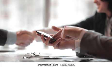 Nahaufnahme.Ein Geschäftsmann verwendet während einer Geschäftstagung ein Smartphone.