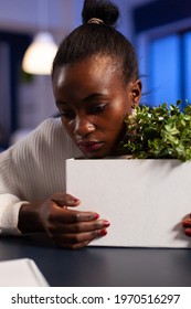 Close Upf Sad Depressed African Woman After Bing Dismissed From Work During Economy Crisis. Unemployed Packing Things Late At Night. Woman Leaving Workplace Office In Midnight.