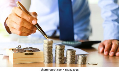 Close up,Hand putting money coins stack in saving money and growing business concept.