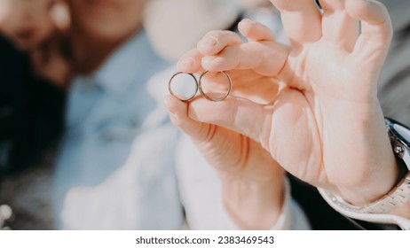 Close ups of bride and groom showing their wedding rings, holding hands together - Powered by Shutterstock