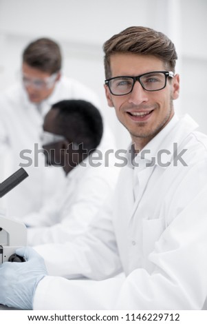 close up.serious scientist scientist sitting at the table
