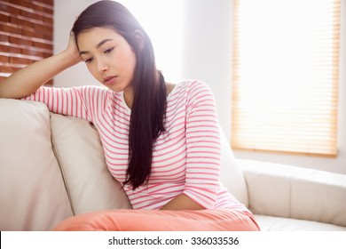 Close up of upset asian woman on couch at home in the living room - Shutterstock ID 336033536