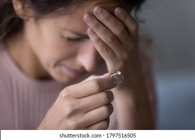 Close Up Of Upset Young Woman Hold Wedding Ring Disappointed With Marriage Dissolution, Unhappy Sad Millennial Caucasian Female Suffer After Cheating Or Breakup, Frustrated With Relationships Problems