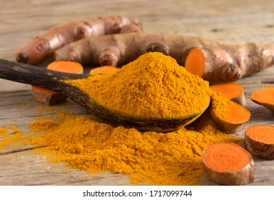 Close up,Turmeric powder and fresh turmeric (curcumin) rhizome on a wooden background,Turmeric is used to produce medicine,copy space.