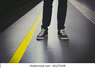 Close Up Of Urban Man Feet In Sneakers On Subway Platform. Urban Life Concept.