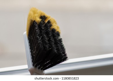 Close up of an used brrom in front of a window