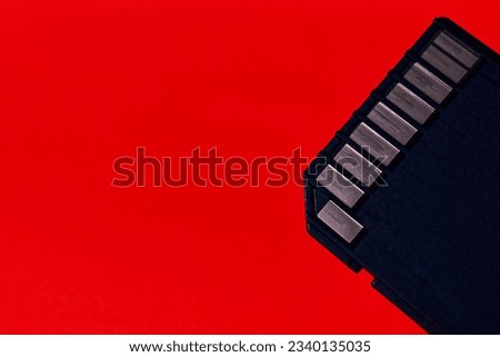 Close up of a used SD card in 45° angle with red to orange backrop.