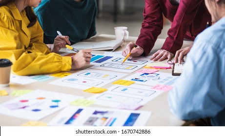 Close up ux developer and ui designer brainstorming about mobile app interface wireframe design on table with customer breif and color code at modern office.Creative digital development agency - Shutterstock ID 1670742886