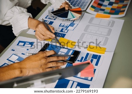 Close up ux developer and ui designer use augmented reality brainstorming about mobile app interface wireframe design on desk at modern office.Creative digital development agency