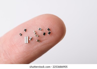 Close up of various electronic microchips on human finger.