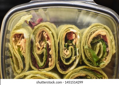 Close Up Of Vegan Tofurky Mini Green Pinwheel Wraps In Plastic To Go Container With Diced Tomatoes And Spinach Healthy Food 