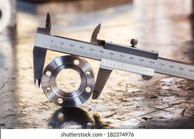 Close up vernier caliper measure diameter of stainless steel flange