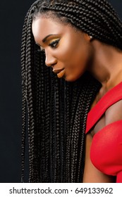 Close Up Vertical Beauty Portrait Of Young African Woman With Long Braided Hair Against Dark Background.