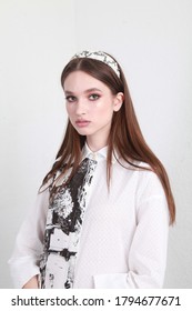 Close Up Vertical Fashion Portrait Of A Teenage Female Model With Professional Make Up And Trendy Hair Band Accssory, Wearing White Cotton Dress And Posing In Studio