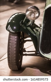 Close up vertical image of the headlight an wheel of a vintage classic car.