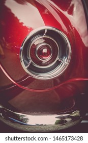 Close up vertical image of the red tail light of a classical vintage car.