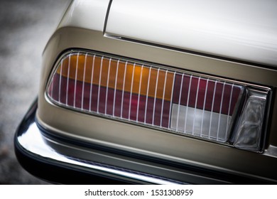 Close up vertical image of the tail light of a classical vintage car.