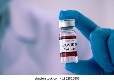 Close up a vial of covid-19 vaccine in hand of a scientist or doctor for watch and prepare to be injected into the public people.