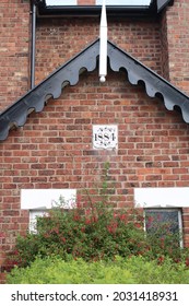 Close Up Victotrian Red Brick House Built In 1884 With Date Plaque And Decorative Wooden Roof Trim And Finial