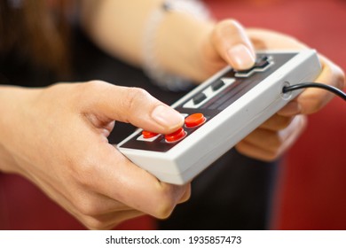 Close up to video game wired controller, woman playing games