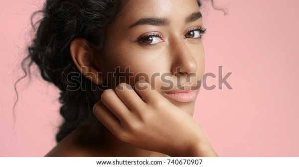 Close up\
video of a happy and relaxed young woman with perfect olive skin\
fixing her wavy black hair isolated on\
white