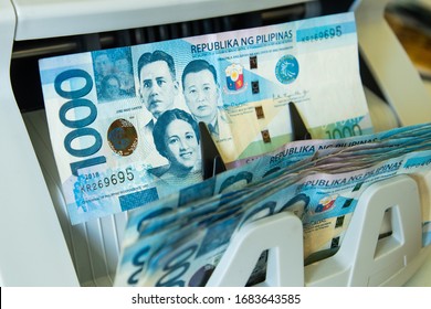 Close Up View Of A 1000 Philippine Peso Cash Exiting The Money Counter Machine