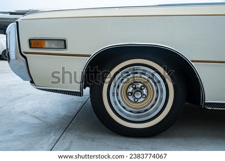 Close up view of 1970's vintage American car with classic white wall tires.